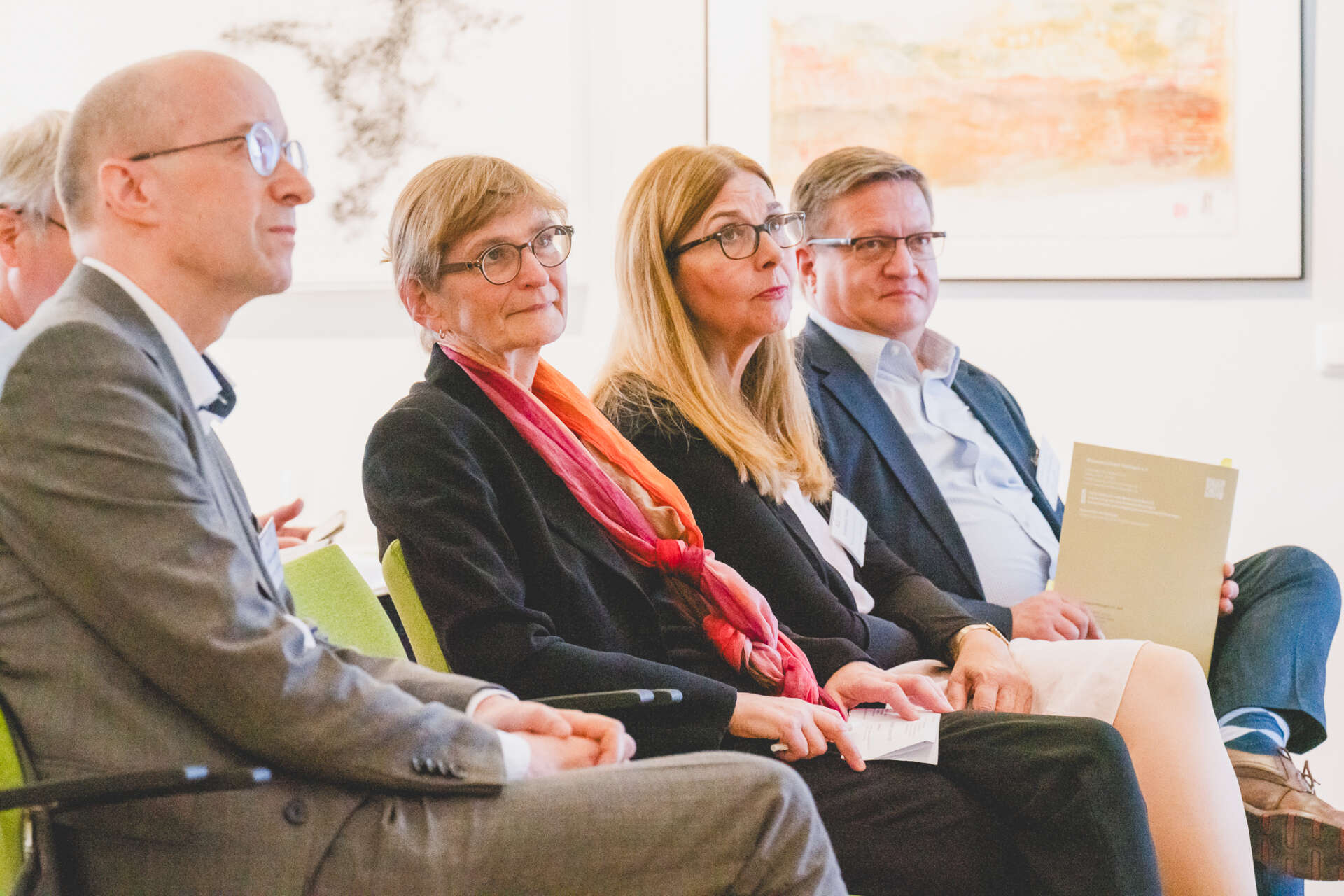 Vier Personen sitzen und hören einem Redner zu, der nicht im Bild zu sehen ist. Von links nach rechts abgebildet sind: Dr. Roland Krischke (Präsident des Museumsverbands Thüringen), Dr. Ute Pott (Vorstandssprecherin der ALG), Prof. Dr. Francesca Vidal (Beisitzerin im Vorstand der ALG) und Bürgermeister Thomas Spielmann.