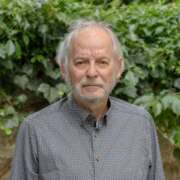 Ein Foto von Bernd Linder vor einem Hintergrund mit Blättern.